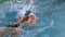 Muscular swimmer doing the front stroke in the pool