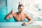 Muscular swimmer shows thumbs up, indoor pool