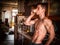 Muscular topless man drinking espresso coffee in kitchen