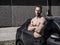 Muscular topless man outside of car