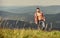 Muscular tourist walk mountain hill. Hiker muscular torso reach mountain peak. Athlete guy relax mountains. Beautiful