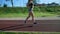 Muscular woman jogging at stadium in morning.