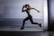 Muscular woman running in exercise room