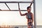 Muscular woman standing by monkey bars