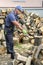 Muscular young man chopping logs