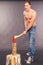 Muscular young man chopping logs