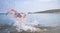 Muscular young man dives from the shore in to the sea