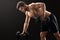 Muscular young man exercising with dumbbells