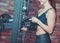 Muscular young smilling woman holds iron disk of barbell.