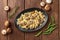 Mushroom and cheese pasta. Farfalle with cremini and green peas, shot from the top with ingredients on a rustic wooden background