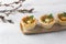 Mushroom julienne with quail egg and cheese in a puff pastry basket on a light blue background. Easter style with willow