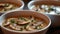 mushroom soup, the hearty combination of champignons, paprika, potatoes, meat, and spices in white bowls set on a dark