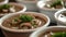 mushroom soup, the hearty combination of champignons, paprika, potatoes, meat, and spices in white bowls set on a dark