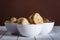 mushrooms and artichokes in oil in ceramic bowl on white wooden background