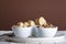 mushrooms and artichokes in oil in ceramic bowl on white wooden background