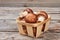 Mushrooms in basket on wood.