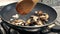 Mushrooms cut into thin slices and garlic cooking in a pan with a little olive oil