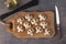 Mushrooms in the form of skulls on wooden board, also olive oil and raw black spaghetti, Edible Halloween cooking