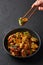 Mushrooms Manchurian dry in black bowl at dark slate background