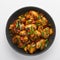 Mushrooms Manchurian dry in black bowl isolated at white background