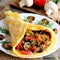 Mushrooms omelette with fresh tomatoes and dill on a white plate and on a wooden table. Rustic style. Closeup