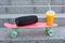 A music bluetooth speaker, orange juice and plastic skateboard, a close-up