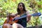 Music Concept: Young and Beautiful woman playing Spanish guitar outdoors in a park