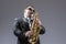 Music Concepts. Portrait of Mature Expressive Caucasian Saxophone Player in Sunglasses Playing the Saxophone in Studio