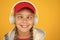 Music with emotions. Squint-eyed kid on yellow background. Funny child listen to music in stereo headphones. Small child