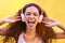 Music, face and shouting with a black woman listening to the radio outdoor on a yellow wall background. Headphones