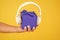 Music gift conept. gift box with headphones. male hand hold present yellow backdrop. modern headset. what is inside