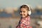 Music gives her great pleasure. Cute child with wireless headset. Small child wearing stereo headphones. Little child
