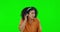 Music, green screen and woman listening to headphones ask to hear louder isolated in a studio background while dancing