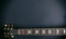 Music, guitar. Top view of a guitar neck fretboard and headstock against black background