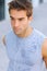 Music helps me exercise. Closeup of a handsome young man in a sweaty shirt listening to music on his earphones.