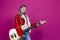 Music Ideas. Caucasian Guitar Player With Yellow Bass Guitar Posing In Fashionable Red Jacket Over Trendy Pink Background