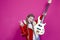 Music Ideas. Expressive Caucasian Female Guitar Player With Yellow Bass Guitar Posing In Fashionable Red Jacket With V Gesture