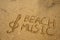 Music key and text beach music drawn on a sand.