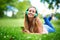 Music and nature soothes the soul. a young woman listening to music while lying on the grass at the park.