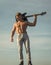 Music, performance, entertainment. Man with muscular torso hold electric guitar on blue sky.