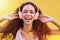 Music, portrait and freedom with a black woman listening to the radio outdoor on a yellow wall background. Headphones