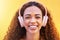 Music, portrait and smile with a black woman listening to the radio outdoor on a yellow wall background. Headphones