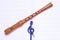 Music school concept: music sol key shaped pencil  and wooden sweet flute rest on an empty music score with copy space for your te
