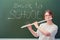 Music teacher plays flute near blackboard with text