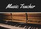 Music teacher text banner over piano against black background