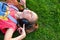 Musical cheerful mood. A young girl lies on the grass and listens to music on headphones