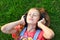 Musical cheerful mood. A young girl lies on the grass and listens to music on headphones