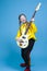 Musical Concepts. One Winsome Caucasian Female Guitar Player With White Bass Guitar Holding Instrument Nearby With Playful