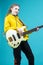 Musical Concepts. One Winsome Caucasian Female Guitar Player With White Bass Guitar Holding Instrument Nearby With Playful