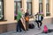 A musical group of three people on an old European street. The band consists of two men and one girl. Men with a double bass and a